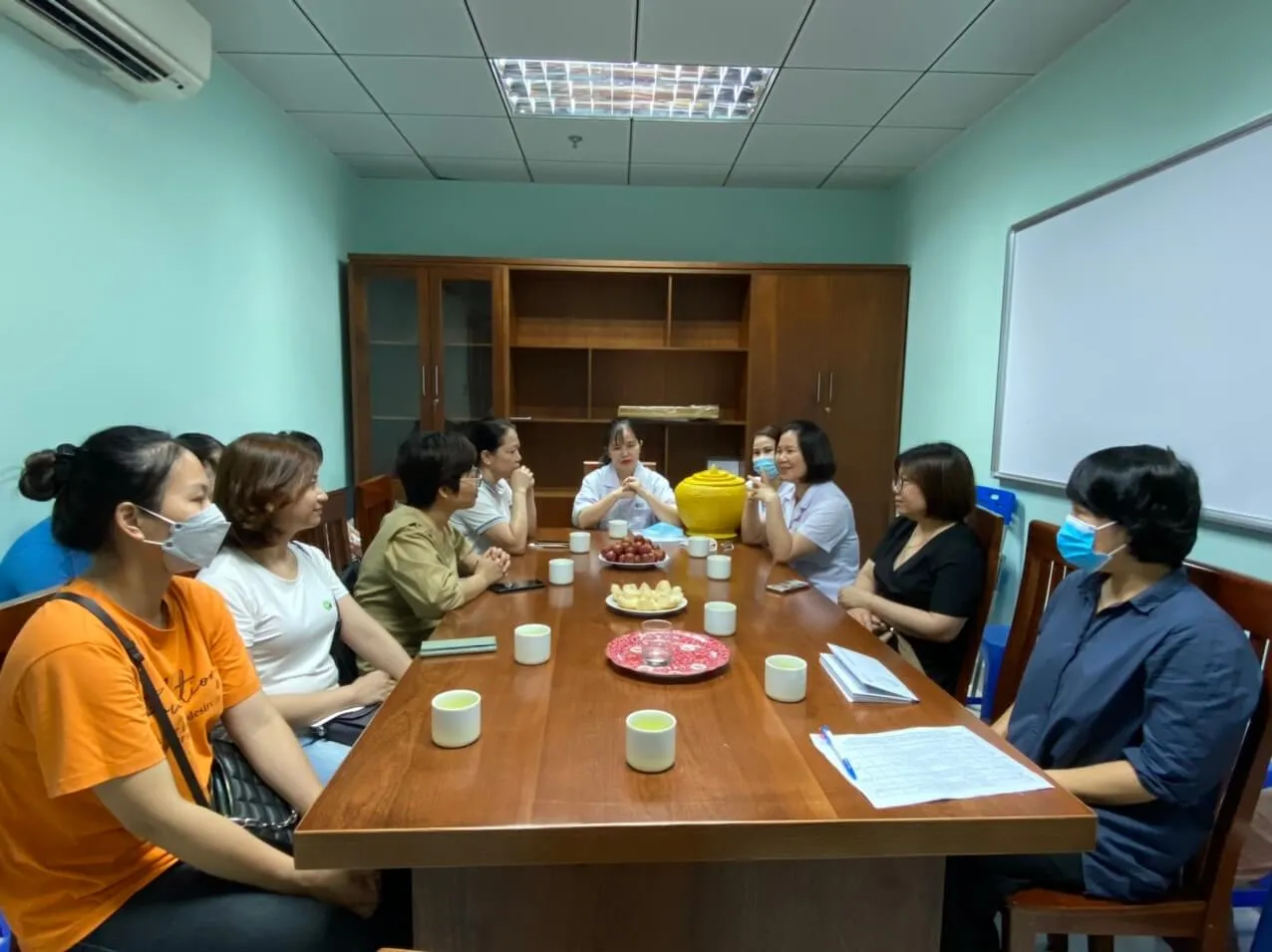 Đoàn thiện nguyện trao hỗ trợ cho gia đình bệnh nhi trước bức tranh hoa hướng dương