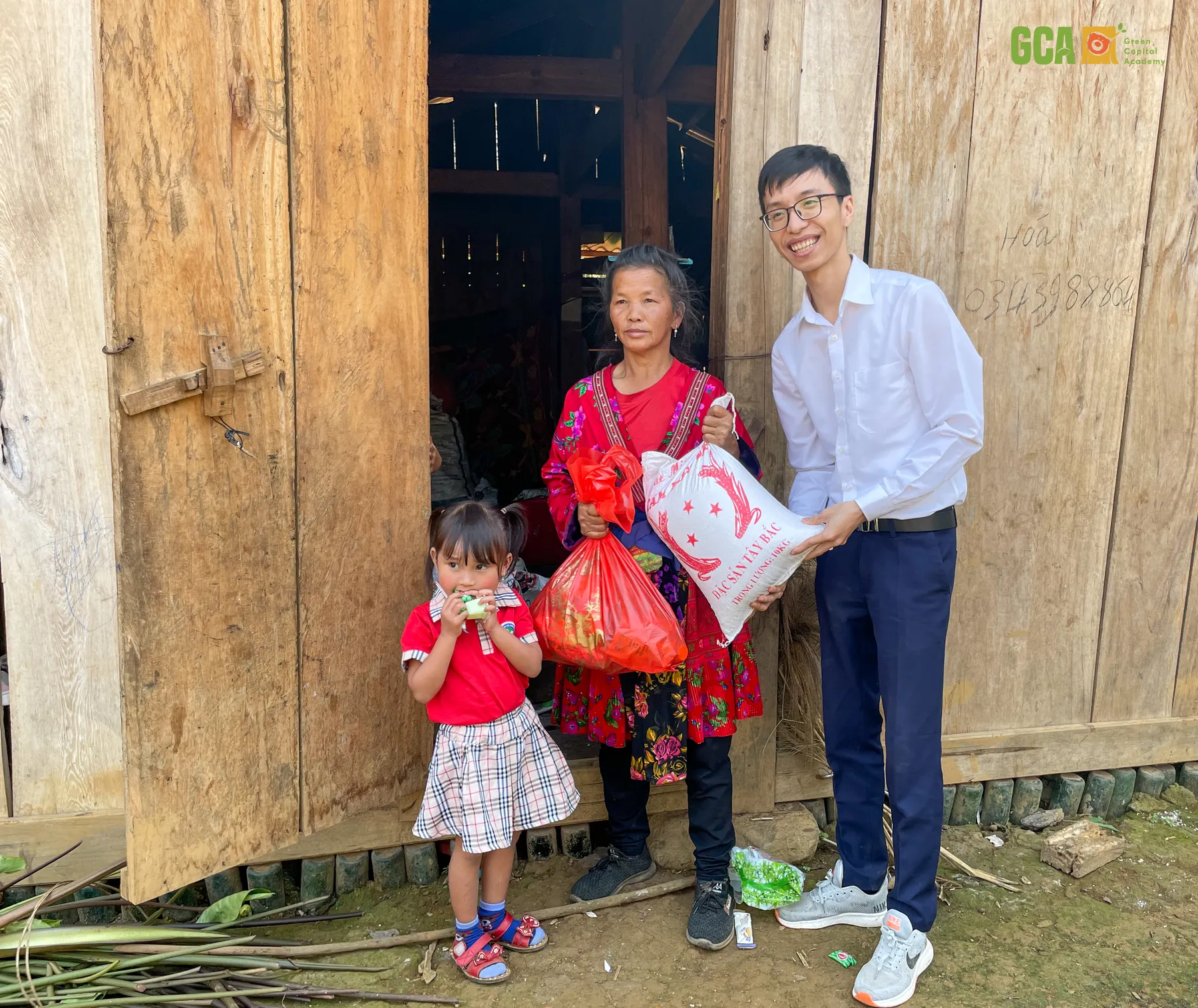 Thành viên đoàn trao quà cho một gia đình học sinh